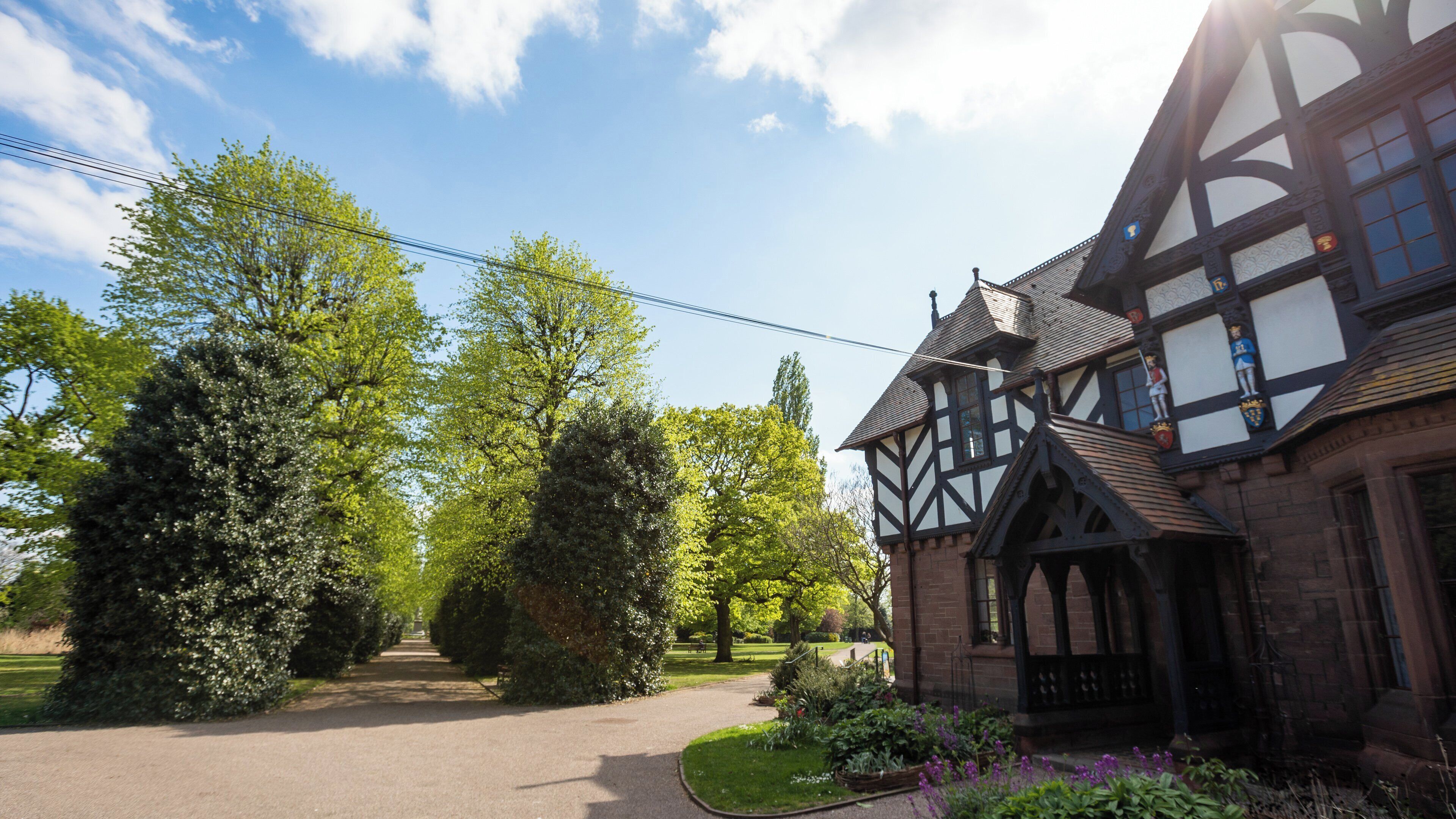 A Tudor-style building with a paved pathway leading to the entrance.