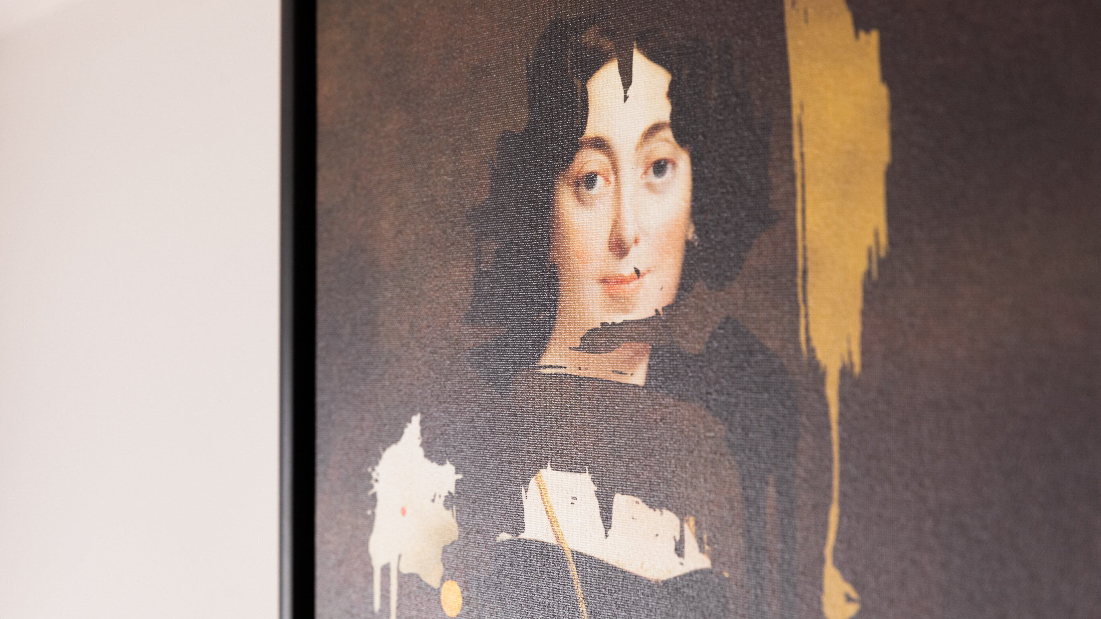 A framed artwork with a dark background and a figure in a dark outfit.