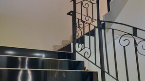 A staircase with black railings and a framed picture of a butterfly on the wall. - Wawasan Homestay Butterworth (Butterworth)