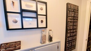 A wall with framed shells and a motivational quote. - Charming 2nd Row remodel with Beach Views (Surfside Beach)