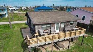 A two-story house with a wooden deck and a covered outdoor area. - Charming 2nd Row remodel with Beach Views (Surfside Beach)