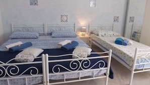 Un dormitorio con dos camas, una mesita de noche, una lámpara y un espejo.