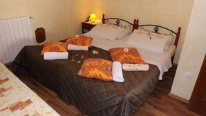 A neatly made bed with a brown quilt, two pillows with floral patterns, and a rolled towel. - Apartment in Umag with WIFI (853-2) (Umag)