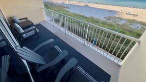 Een balkon met uitzicht op een strand en zee.