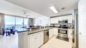 Een moderne keuken met witte kasten, roestvrijstalen apparatuur en een groot eiland.