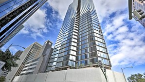 A tall, modern skyscraper with a glass facade and a prominent vertical design element. - Downtown Honolulu Suite Near Ala Moana Beach! (Honolulu)