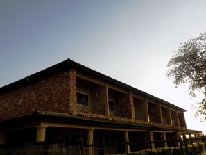 A building with a stone facade, a flat roof, and a covered front porch with columns. - Soroti Hotel (Soroti)