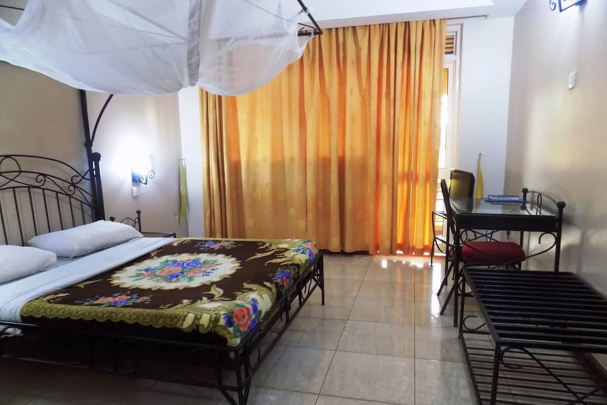 A room with a bed, a desk, and a chair.