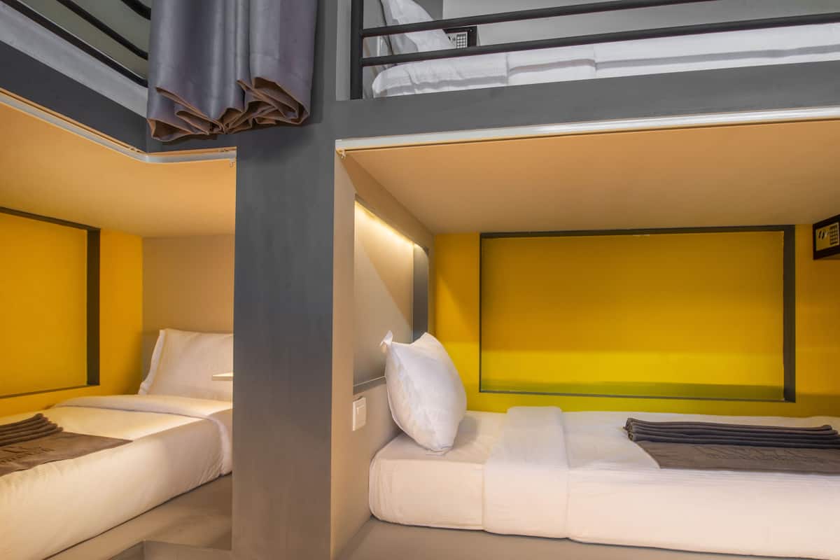 Une chambre d’hôtel moderne équipée d’un lit superposé et d’un canapé-lit.