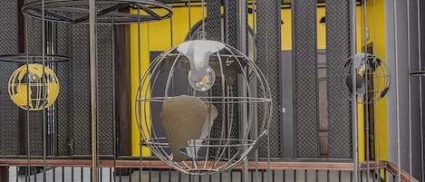 Un atrio de varios niveles con un diseño industrial moderno, que incluye barandillas metálicas a la vista y lámparas colgantes esféricas.