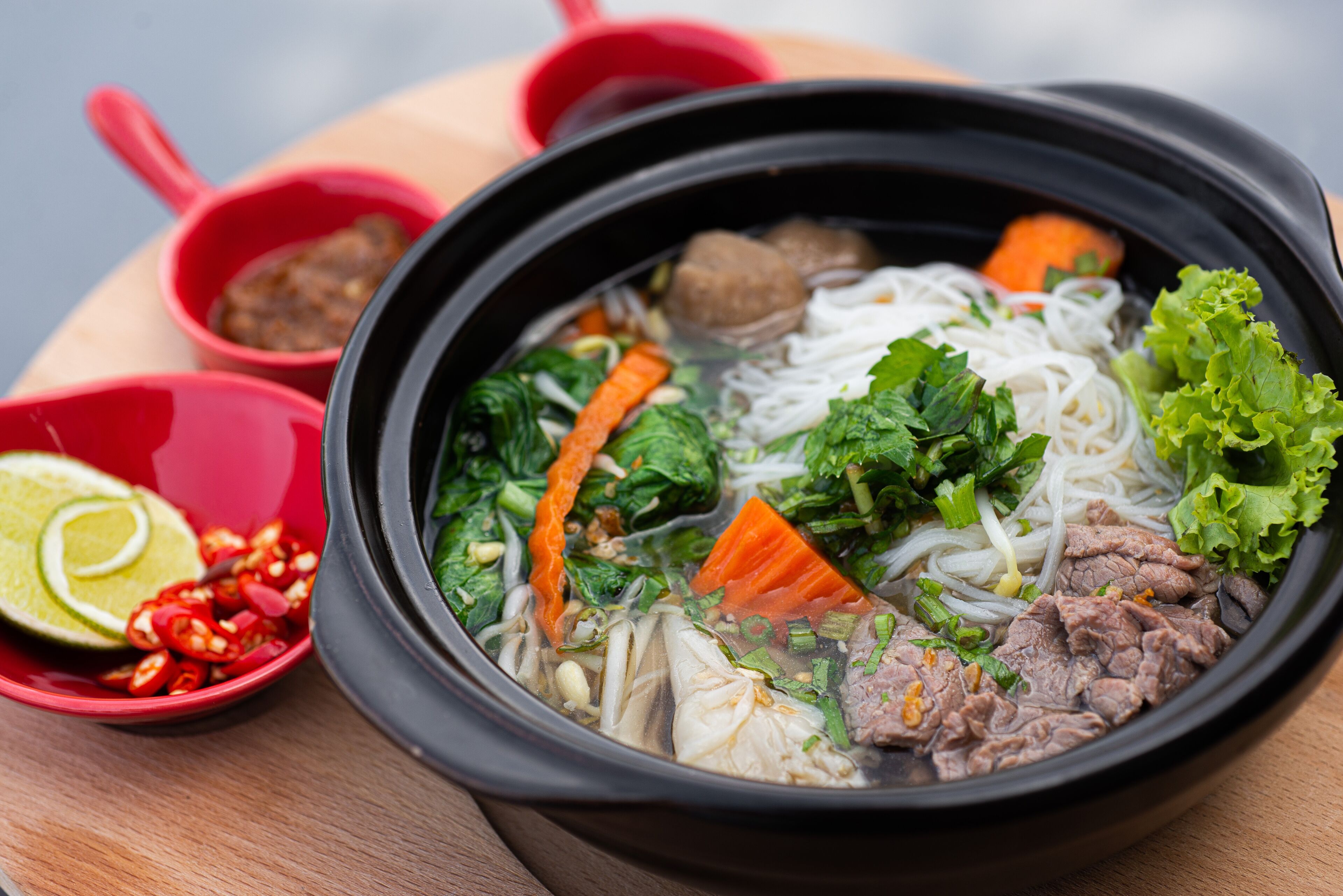 A bowl of soup with noodles, meat, and vegetables.