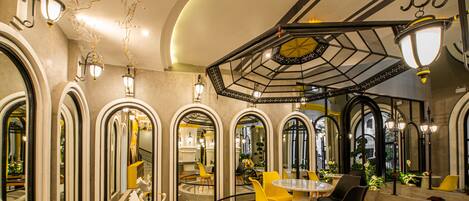 A modern interior with a circular seating area, arched mirrors, and decorative lighting.