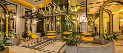 A lobby with a central seating area, a staircase, and decorative elements.