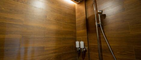 A shower area with wooden walls and a metal showerhead.