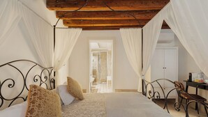 Un dormitorio con una cama, dos almohadas, una mesita de noche y un escritorio con una silla.