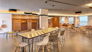 A spacious conference room with a long table, multiple chairs, and a modern ceiling design. - Ginger Sanand (Sanand)