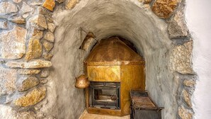 A stone archway leading to a fireplace with a metal pot hanging above it. - Beautiful stone holiday house MENTA I (Bajcici)