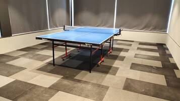 A ping pong table in a room with a checkered floor pattern.
