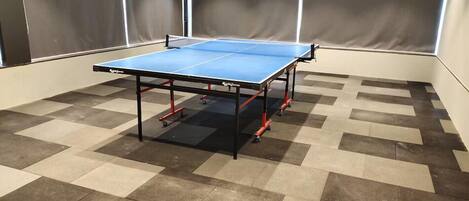 A ping pong table in a room with a checkered floor pattern.