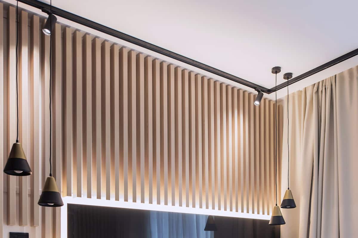 A modern hotel room with a large bed, a round side table, and a wall-mounted light fixture.