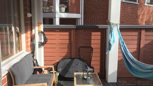 A wooden deck with a sofa, chairs, and a small table. - Large artsy apartment in Pasila (Helsinki)