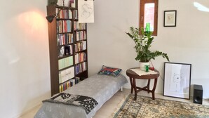 A cozy bedroom with a bed, a bookshelf, a potted plant, and a framed picture on the wall. - Large artsy apartment in Pasila (Helsinki)