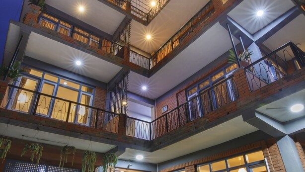 A multi-story building with balconies, potted plants, and a well-lit entrance. - Pacific Guest House (Kathmandu)