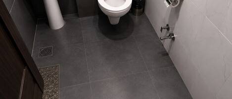 Une salle de bain équipée de toilettes, d’un lavabo et d’une poubelle.