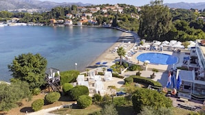 Un resort costero con piscina, tumbonas y vistas al mar.