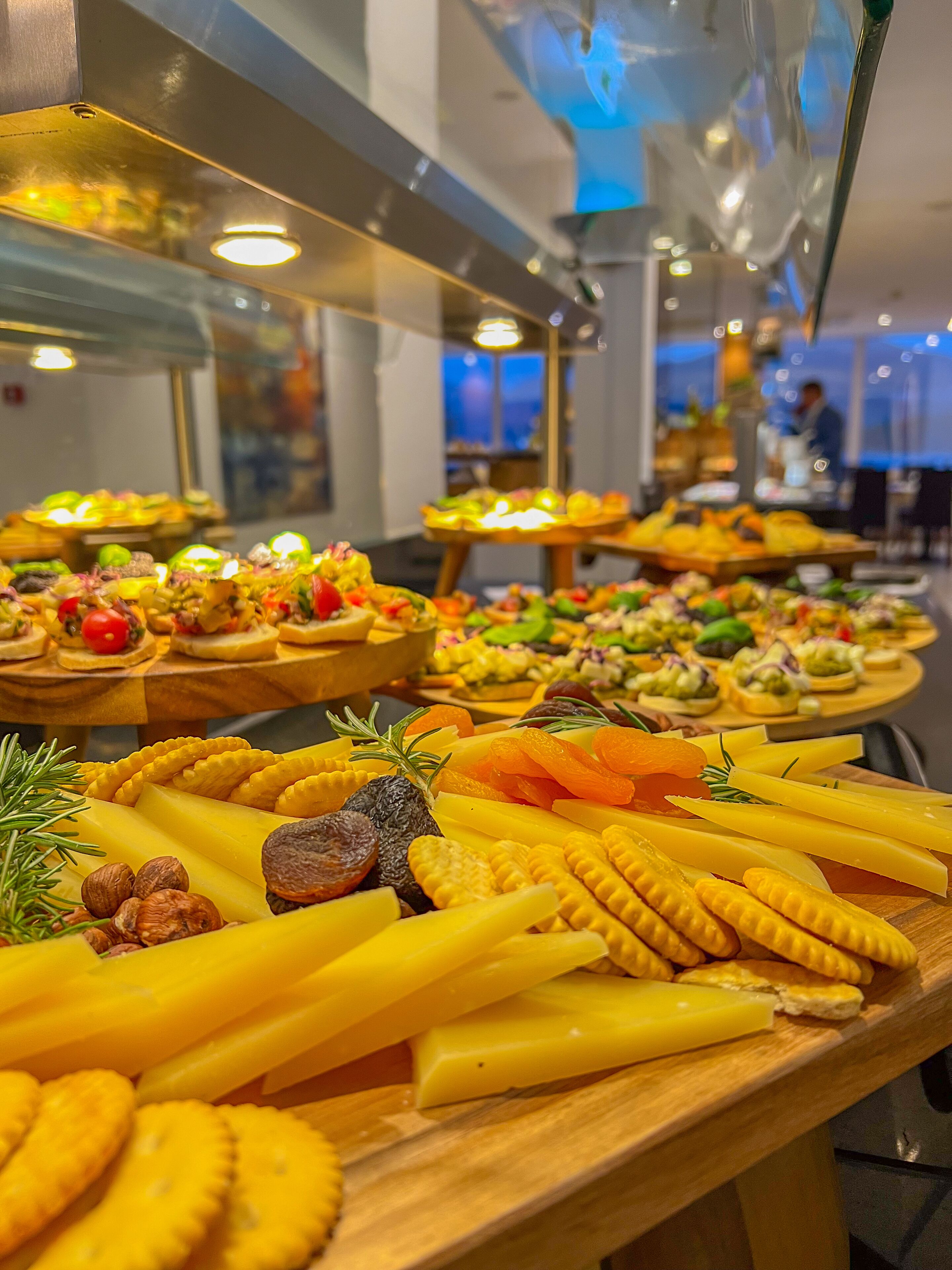 Un buffet proposant une variété d’aliments, notamment des fromages, des noix et des biscuits salés.