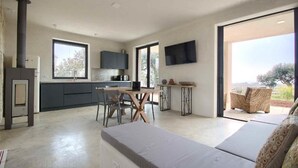 Una cocina moderna con comedor, sofá y televisor.