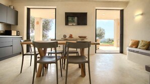 Una cocina moderna con comedor, que incluye una mesa grande, sillas y un televisor de pantalla plana montado sobre la mesa.