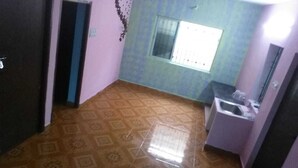 A room with a patterned floor, a window with blinds, a sink, and a door. - serenity beach house (puducherry)