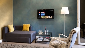 A modern living room with a sofa, a coffee table, a chair, and a flat-screen TV mounted on the wall. - Casa Pacifico (Pompei)