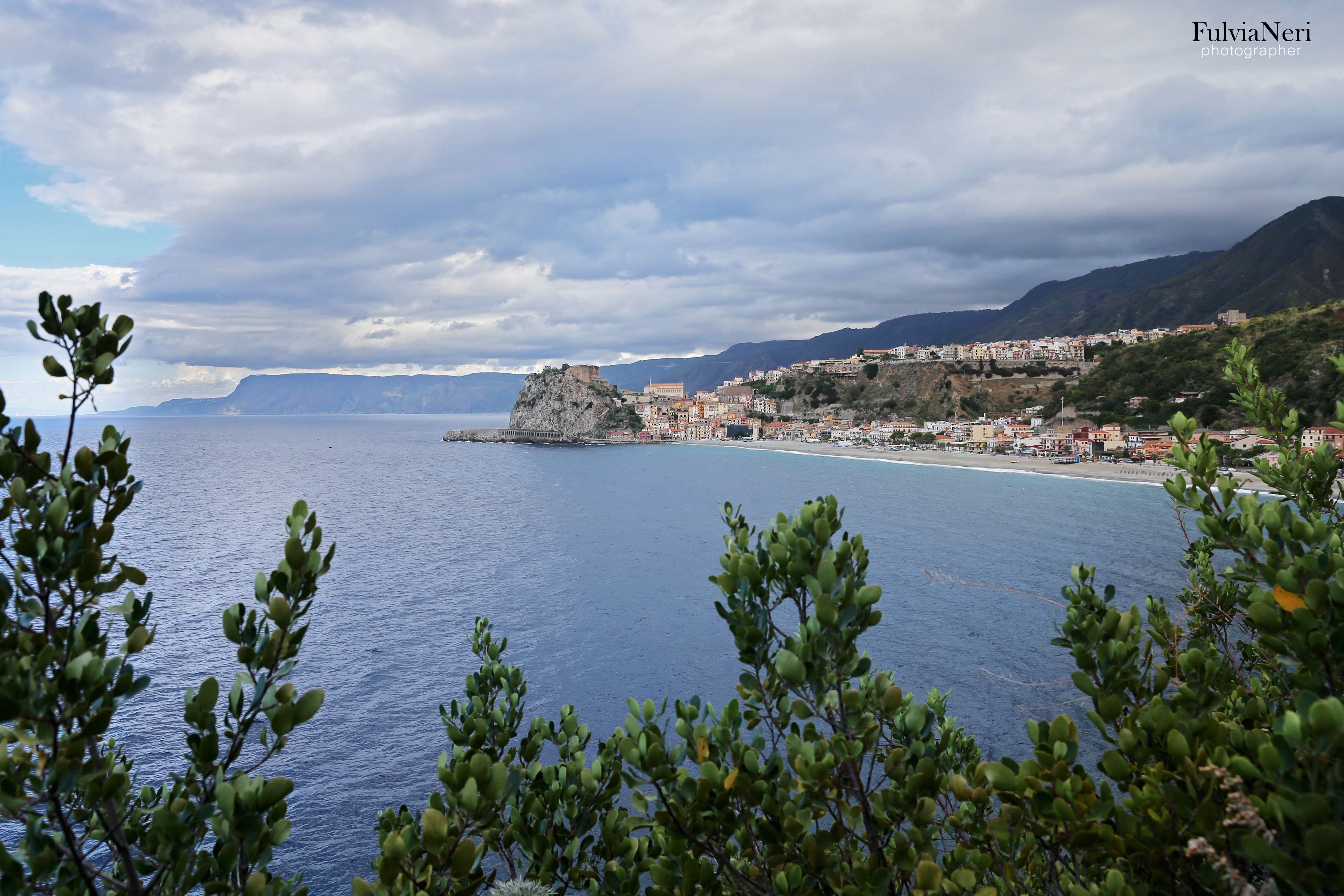 Una località costiera con un'imponente scogliera e edifici lungo la linea di costa.