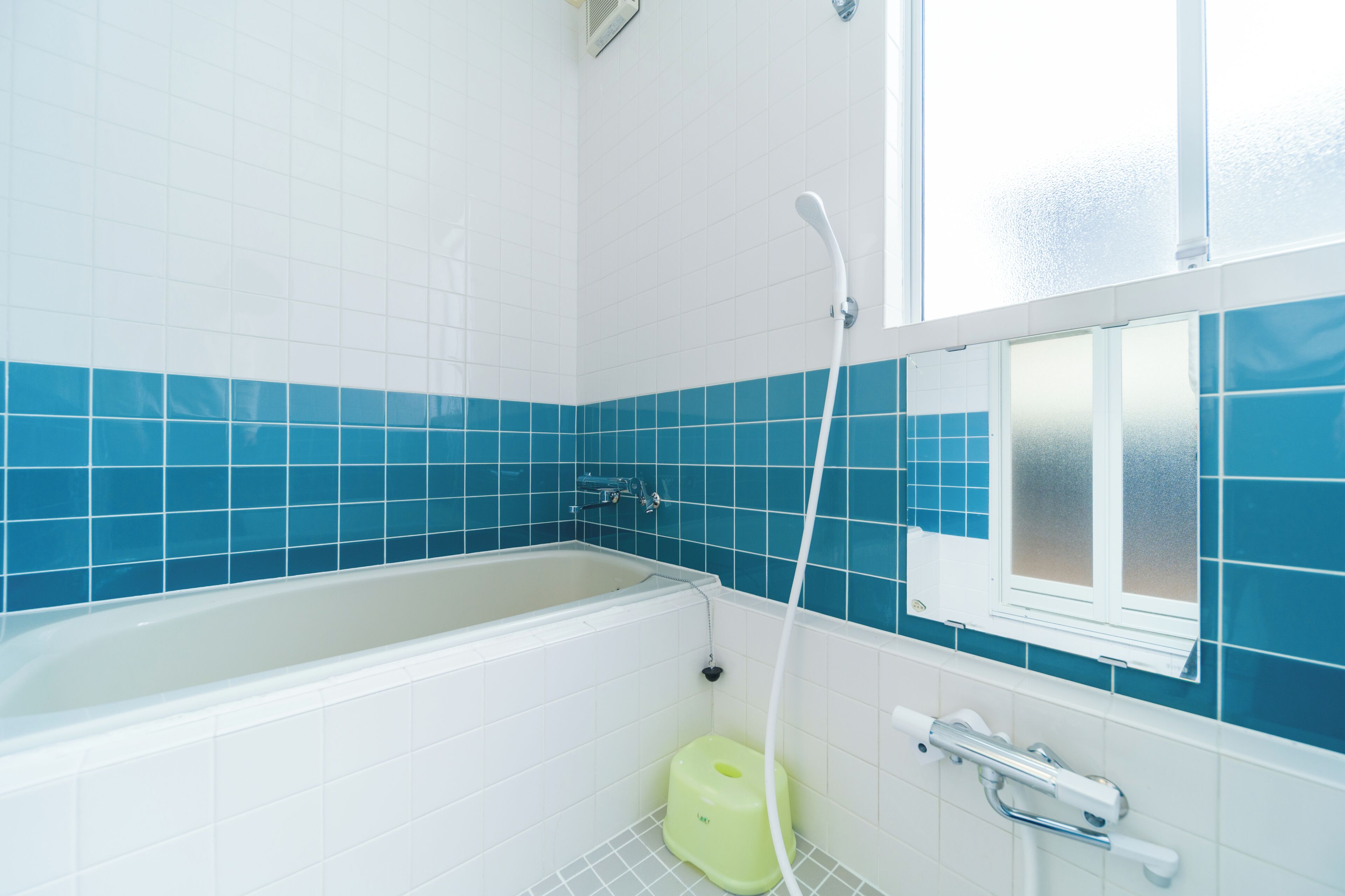 Ein Badezimmer mit einer Badewanne, einem Fenster und einer Toilette.