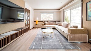 A modern living room with a sofa, a coffee table, and a TV. - Yama House Hakuba (Hakuba)