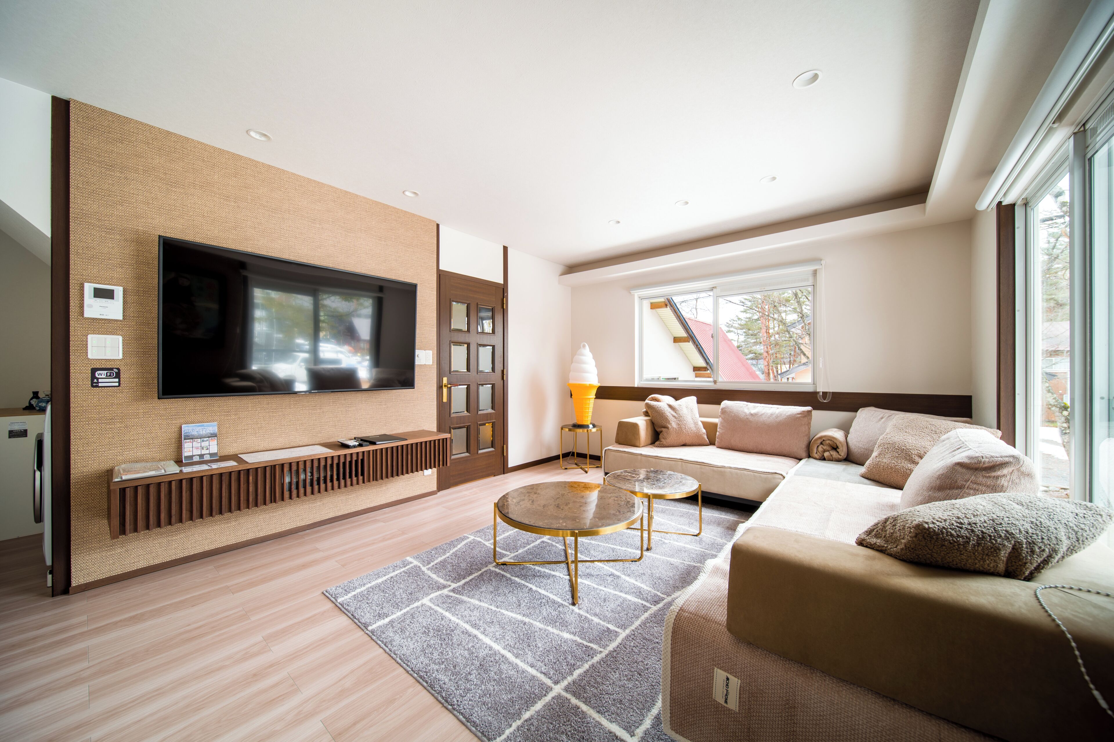A modern living room with a flat-screen TV, a sofa, a coffee table, and a fireplace.