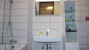 Ein Badezimmer mit Badewanne, Waschbecken und Dusche.