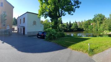 Ein Gebäude mit Parkschild, Teich und einem Weg.