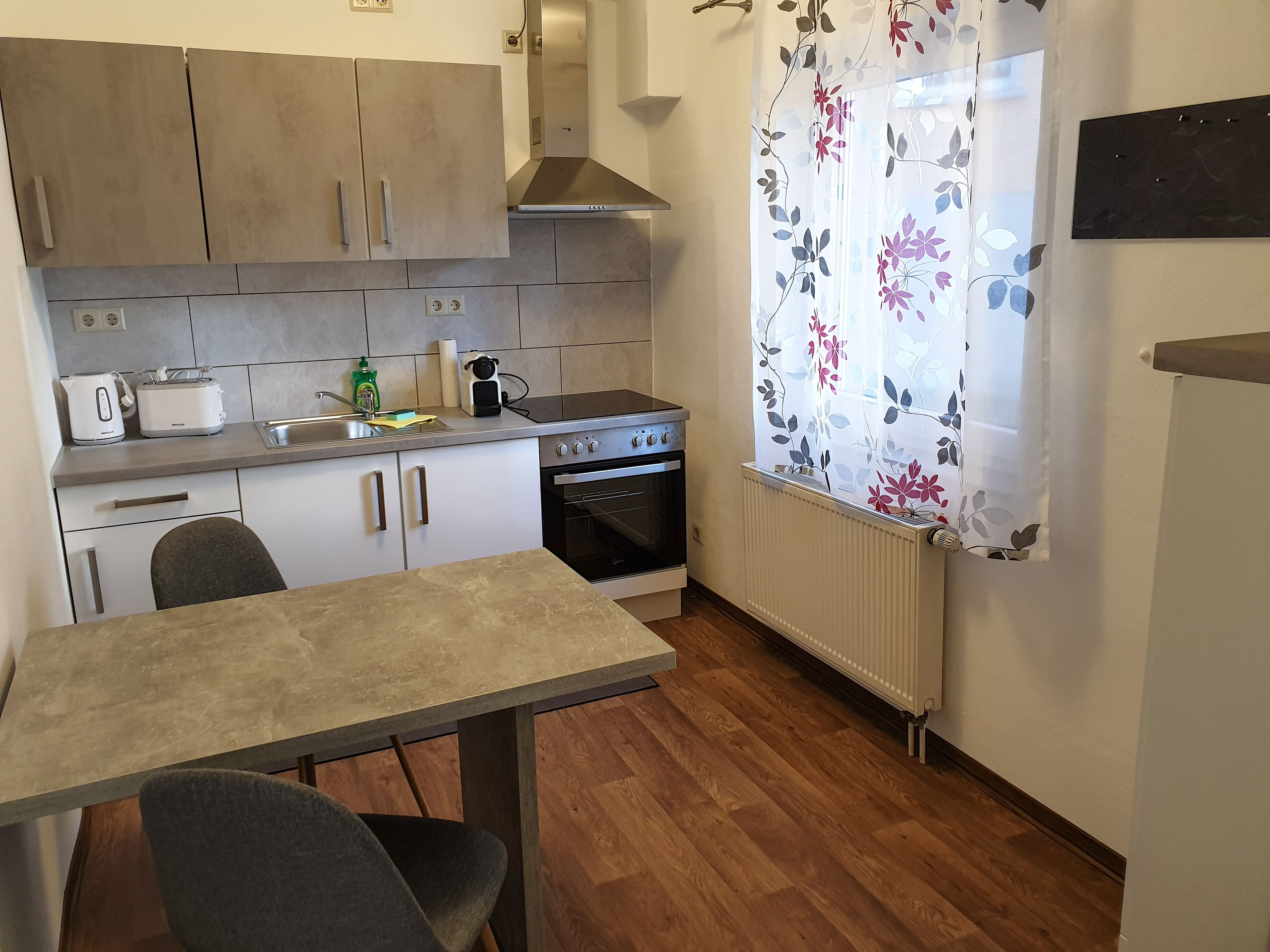 Una cocina compacta con una mesa de comedor, estufa y pileta.