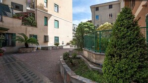Un patio con un sendero empedrado, paredes de piedra y plantas en macetas.
