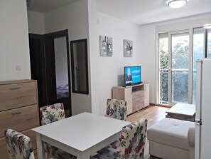 Apartemen Comfort, pemandangan halaman | Area keluarga | TV layar datar