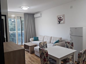Departamento Confort, vista al patio | Área de sala de estar | Televisión de pantalla plana 
