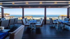 A restaurant with a terrace overlooking the sea, featuring tables and chairs arranged for dining. - HVD Club Hotel Miramar - Ultra All Inclusive (Obzor)