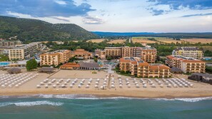 A coastal resort with multiple buildings, a beach with sun loungers, and a view of the sea. - HVD Club Hotel Miramar - Ultra All Inclusive (Obzor)