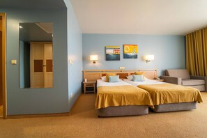 A hotel room with two beds, a sofa, a nightstand, and a mirror. - HVD Club Hotel Miramar - Ultra All Inclusive (Obzor)