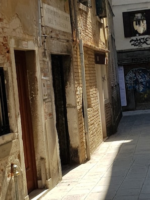 A narrow alleyway with aged brick walls and a tiled pavement. - Lovely Apartment In Venice (Venice)