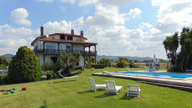 A large house with a swimming pool, surrounded by a well-maintained lawn and palm trees. - B&B La Mia Casa per Tutti (Cerveteri)