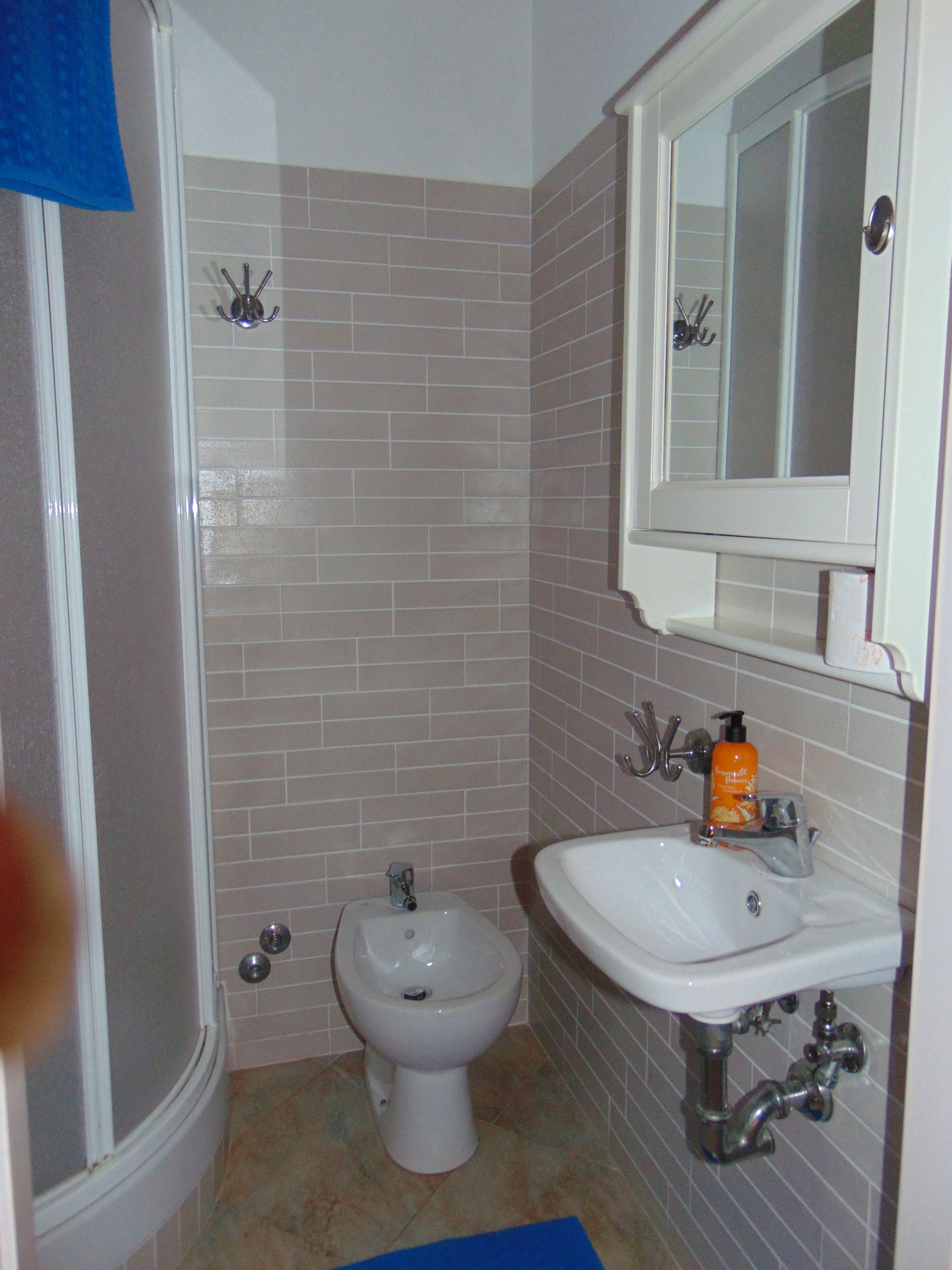 A bathroom with a shower, toilet, and sink.